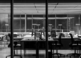 Stylish black and white photo of a modern empty office space, featuring sleek furniture and large windows.